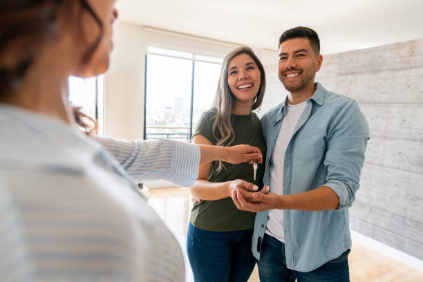 Real estate agent handing keys to new homeowners